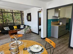 a kitchen and a living room with a table at Appartement Le Jardin Imaginaire in Champagnole
