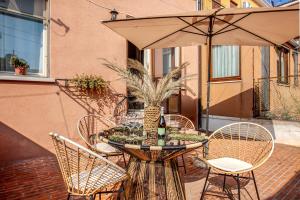 Una mesa con sillas y una sombrilla en un patio. en MURANO Place - CALCEDONIO & Courtyard, en Venecia