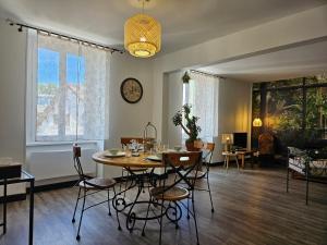 a dining room with a table and chairs at Appartement Le Jardin Imaginaire in Champagnole