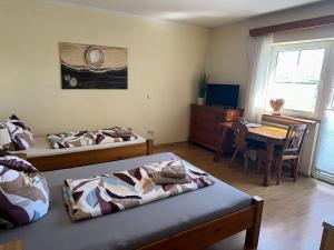 a bedroom with two beds and a desk and a table at Seehaus Mamming - Hotel - Schlaffässer - Biergarten - Camping in Mamming