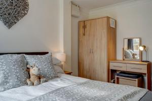 a bedroom with a bed with a teddy bear on it at Robins Rest by Winterton Cottages in Hemsby