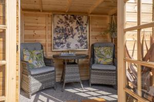 two chairs and a table on a porch at Robins Rest by Winterton Cottages in Hemsby