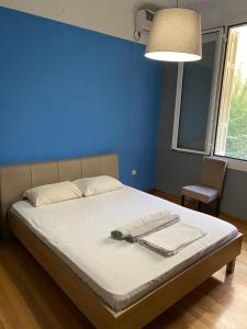 a bed in a room with a blue wall at Kolonaki Private Rooms in Athens
