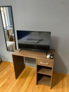 a flat screen tv sitting on top of a wooden table at Kolonaki Private Rooms in Athens