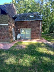 a brick house with a patio and a white bench at Studio Ceder 1 in Houthalen-Helchteren
