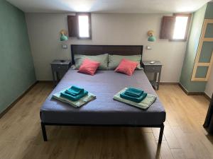 una camera da letto con un letto con due asciugamani sopra di La terrazza nel borgo a Tortora