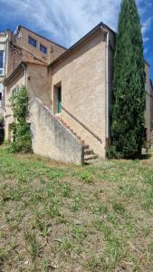a building with stairs and a tree in front of it at Charmant t2 idéal Curiste 1min à pied de la cure thermale in Le Boulou