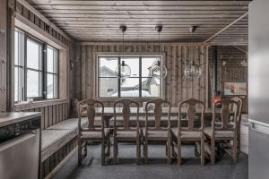 a dining room with a table and four chairs at Lyxig stuga på Branäsberget in Sysslebäck