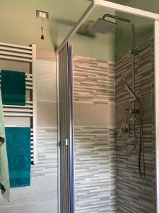 una doccia con una porta in vetro in un bagno di La terrazza nel borgo a Tortora