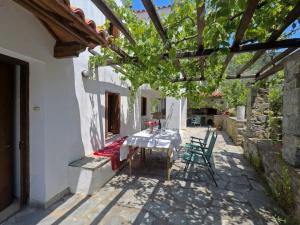 a patio with a table and chairs under a pergola at Klea's House Skopelos in Skopelos Town