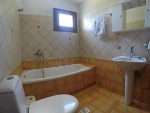 a bathroom with a tub and a sink and a toilet at Klea's House Skopelos in Skopelos Town +24 photos