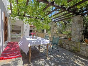 a patio with a table and chairs under a pergola at Klea's House Skopelos in Skopelos Town