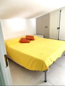 a bed with two red pillows on it in a room at Casa Giulù- in Palermo