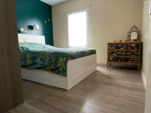 una camera da letto con un letto con una parete verde di Maison d'Évasion entre Plage et Forêt - Charme et Confort à Deux Pas de l'Océan a Saint-Vincent-sur-Jard