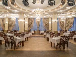a dining room with tables and chairs and a chandelier at Donskaya Roscha Park Hotel in Rostov on Don