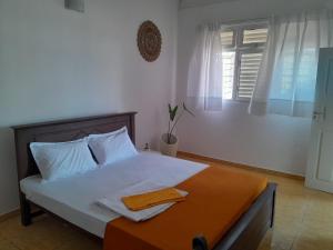 a bedroom with a bed with white sheets and a window at Alkimia in Weligama