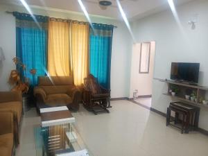 a living room with a couch and a tv at Capital Guest House, Islamabad near Bahria Town , Rawalpindi in Rawalpindi