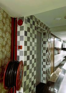 a bathroom with a checkered wall and a mirror at ARK HOTEL MELAWATI in Kuala Lumpur