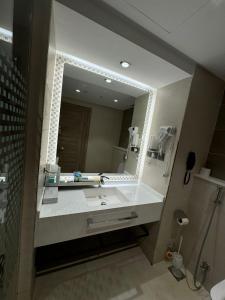 a bathroom with a sink and a large mirror at فندق رؤيا الاندلس النخبة - Roaya Alandalus Elite Hotel in Medina +41 photos
