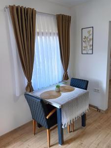 a table and chairs in a room with a window at Villa Medo in Kulen Vakuf