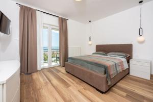 ein Schlafzimmer mit einem Bett und einem großen Fenster in der Unterkunft Tonka Roberta 2 in Crikvenica