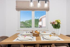 ein Esstisch mit Stühlen und ein Fenster in der Unterkunft Tonka Roberta 2 in Crikvenica