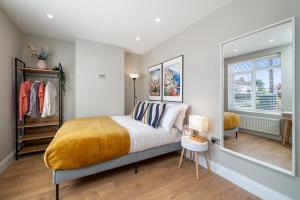 a bedroom with a bed and a large window at Edgeware Home 4 Bedroom House-Free Parking in Edgware