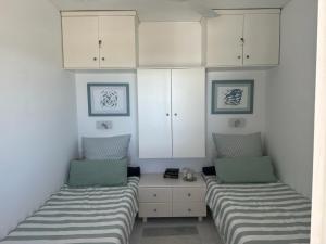 twee bedden in een kamer met witte kasten bij Ferienhaus mit atemberaubendem Meerblick, privatem Pool und Whirlpool in Aliko Beach +54 foto's