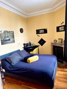 een slaapkamer met een blauw bed en een open haard bij KVS Concept Hébergement haut de gamme près du Circuit des 24 Heures du in Écommoy +10 foto's