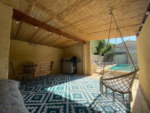 a patio with a table and chairs and a pool at La maison en couleurs 3 étoiles, du calme à 10 minutes d'Avignon in Vedène