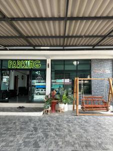 a parking sign in front of a building at Service Apartment Lampang Room101 ใจกลางเมืองใกล้กาดกองต้า in Lampang