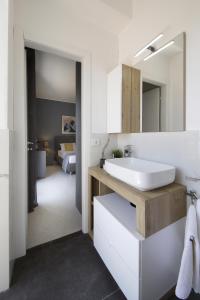a bathroom with a sink and a mirror at Villa Merilusi Apartments in Fontane Bianche