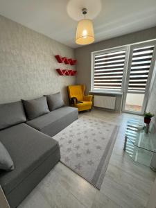 a living room with a couch and a chair at Dārzu ielas apartamenti in Rēzekne