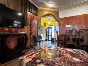 a living room with a flat screen tv and a table at Srinagar Luxury Escape - Dilan Residency in Srinagar