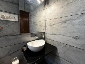 a bathroom with a white sink on a black counter at Srinagar Luxury Escape - Dilan Residency in Srinagar +29 photos