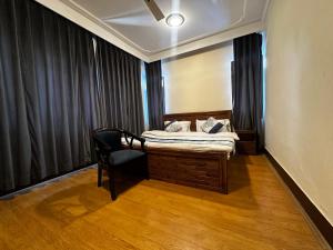 a small bedroom with a bed and a chair at Srinagar Luxury Escape - Dilan Residency in Srinagar
