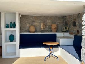 een kamer met een blauwe bank, een tafel en vazen bij Ferienhaus mit atemberaubendem Meerblick, privatem Pool und Whirlpool in Aliko Beach