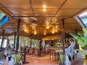a restaurant with tables and chairs under a roof at Koh Chang Bailan Beach Resort in Ko Chang