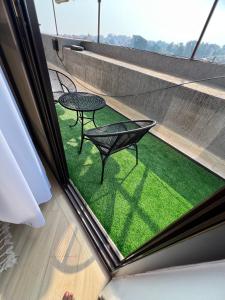 a balcony with a table and chairs on a roof at Skyline residence Kyanja in Kampala