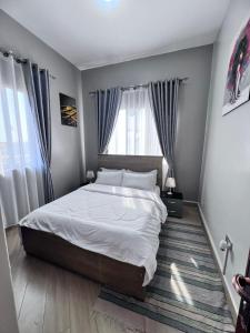 a bedroom with a large bed and a window at Skyline residence Kyanja in Kampala