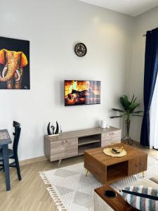 a living room with a tv on a white wall at Skyline residence Kyanja in Kampala