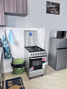 a kitchen with a stove and a refrigerator at Skyline residence Kyanja in Kampala