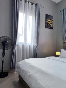a bedroom with a bed and a window with a fan at Skyline residence Kyanja in Kampala