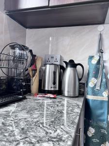 a kitchen counter with a coffee maker and a tea kettle at Skyline residence Kyanja in Kampala