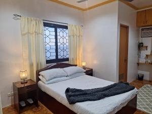 a bedroom with a bed with two lamps and a window at Japitan Waterfront Resort in Dolores