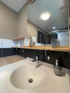 a bathroom with a white sink and a mirror at Appartement coeur de village tous services in Cahuzac-sur-Vère +18 photos