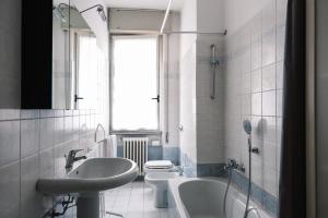 une salle de bain avec deux lavabos et une baignoire et des toilettes dans l'établissement Flora Inn, Paglia 2 - Nel cuore del centro città, à Bergame 41 autres photos