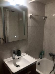 a bathroom with a sink and a mirror and a tub at Central Loft 7 in Kalamata
