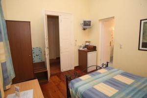 a bedroom with a bed and a table in a room at En Ermoupoli in Ermoupoli