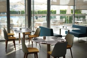 a restaurant with tables and chairs and a large window at Zephyr Agadir in Agadir